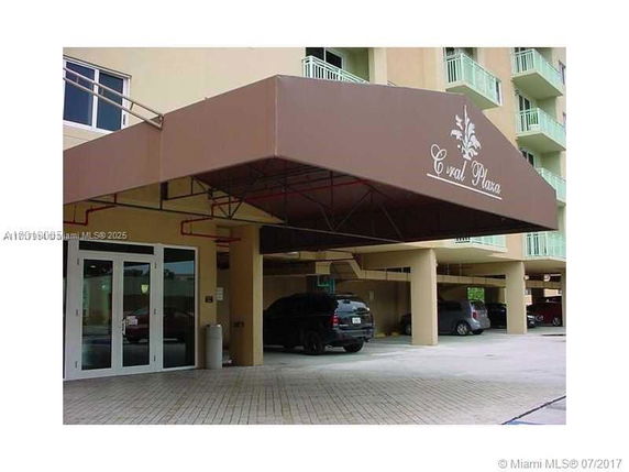 Entrance of a building with a covered parking area and canopy.