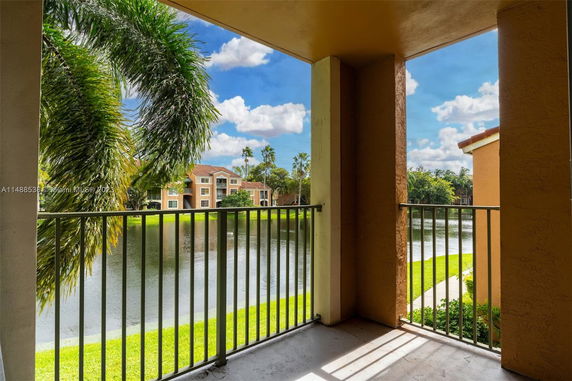 View from a balcony overlooking a body of water and adjacent buildings.