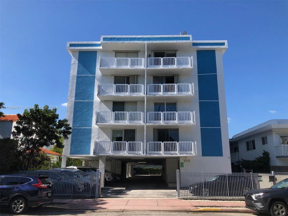 Front view of a multi-story apartment building with a blue and white facade.