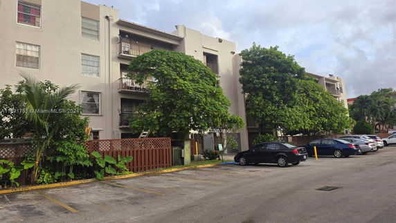 Front view of a multi-story apartment building with balconies.