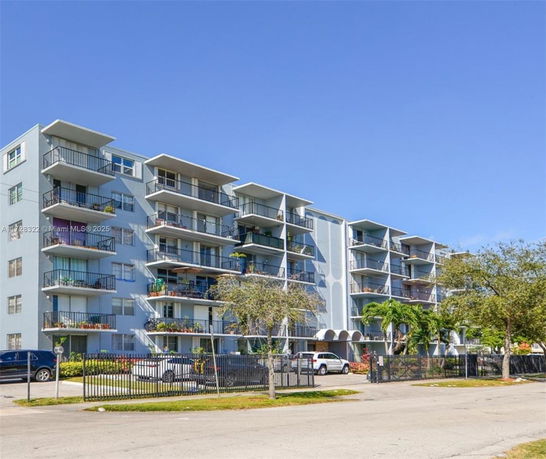 Front view of a multi-story apartment building with balconies.