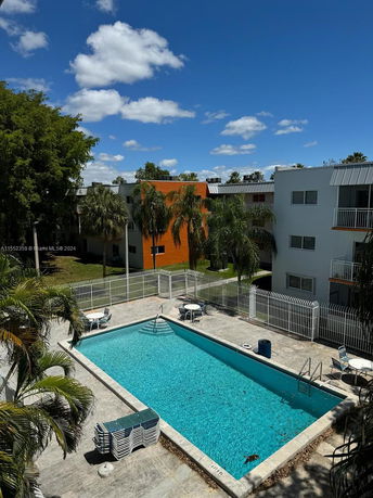 Outdoor swimming pool area with adjacent residential buildings.