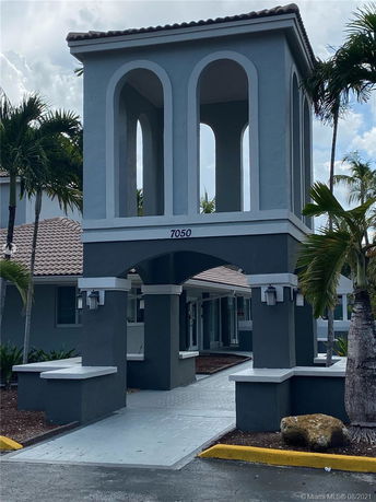 Front view of a building with arched openings and a covered walkway.