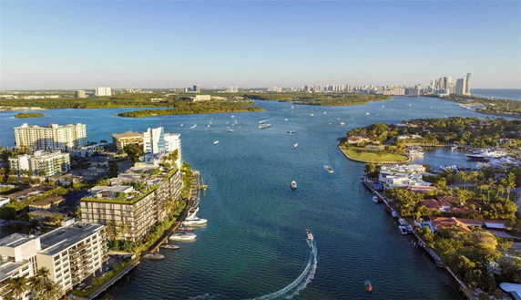 Aerial view of a waterway surrounded by high-rise buildings and residential areas along the coast.