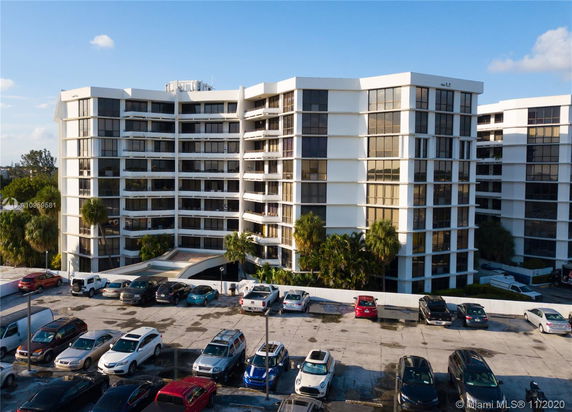 Front view of a multi-story residential building with large windows and balconies.