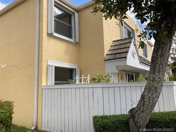 Front view of a two-story house with yellow exterior walls and white trim.