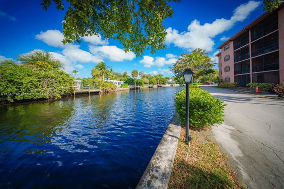 View of a canal bordered by trees and residential buildings.