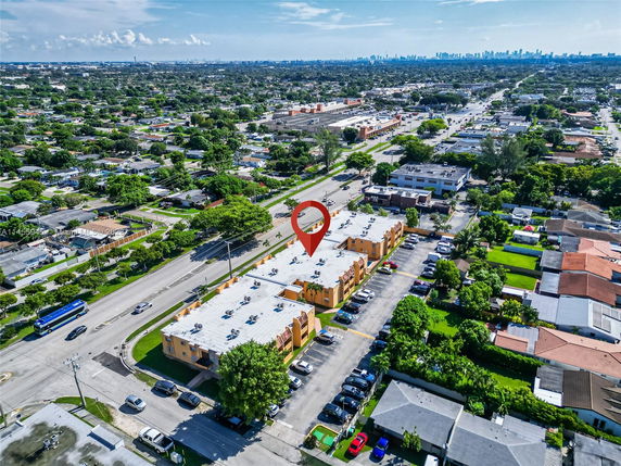 Aerial view of a cityscape with a main road, buildings, and residential areas.