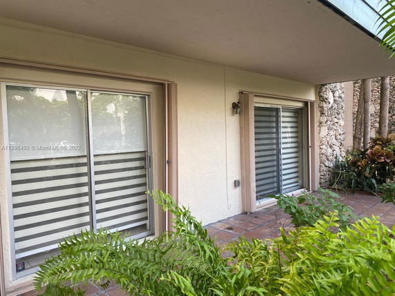 Front view of a house with sliding glass doors and stone wall accents.
