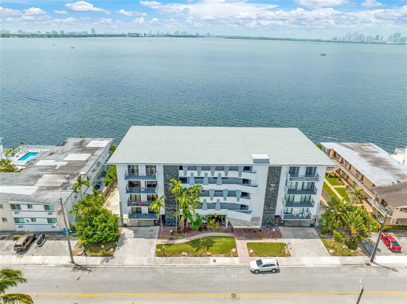 Front view of a multi-story building by a body of water.