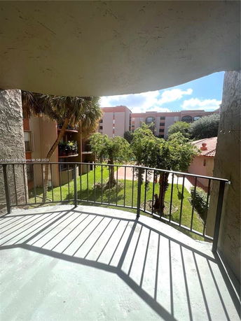 View from a balcony of apartment buildings and trees in a residential area.