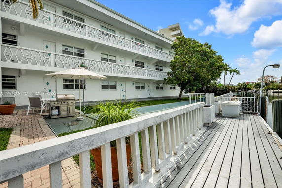 Front view of a multi-story building with balconies and outdoor sitting area.