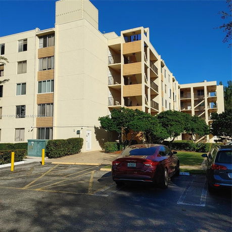 Front view of a multi-story apartment building with balconies.