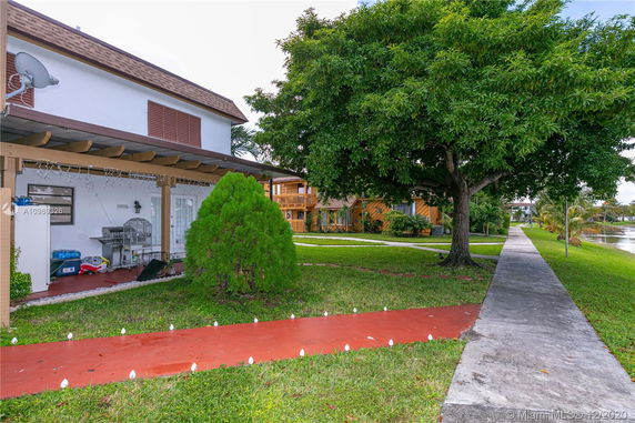 Front view of a two-story house with a pergola and satellite dish.
