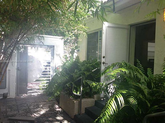 Outdoor area with a door, plants, and a gate.