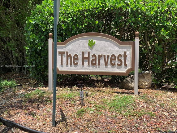 Sign with the text 'The Harvest' in a garden area.