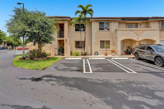 Front view of a two-story residential building with parking spaces.