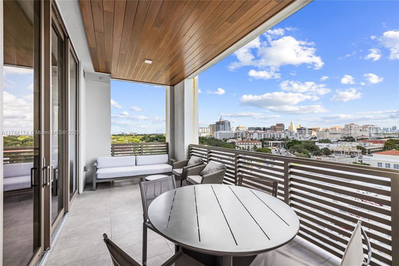 Outdoor balcony area with seating and a view of the city skyline.