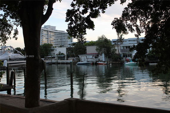 View of waterfront buildings and boats from across a body of water.