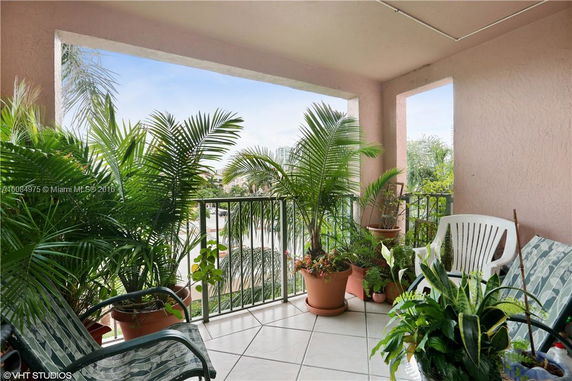 Balcony with plants and outdoor chairs overlooking surrounding area