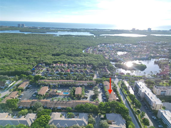Aerial panoramic view of a residential area with nearby waterways and dense green landscapes.