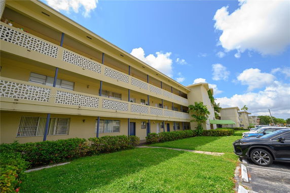 Front view of a multi-story residential building with a patterned facade and balconies.