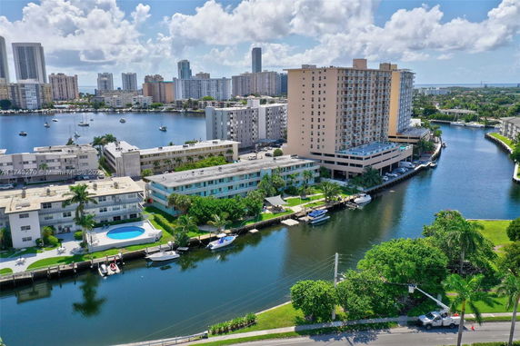 Aerial view of waterfront residential area with high-rise buildings and boats on the water.