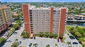 Front view of a multi-story apartment building with adjacent parking lot.