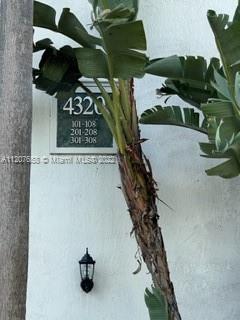 Exterior wall of a building with a lamp and signage indicating apartment numbers.