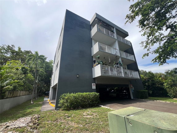 Side view of a multi-story residential building with balconies.