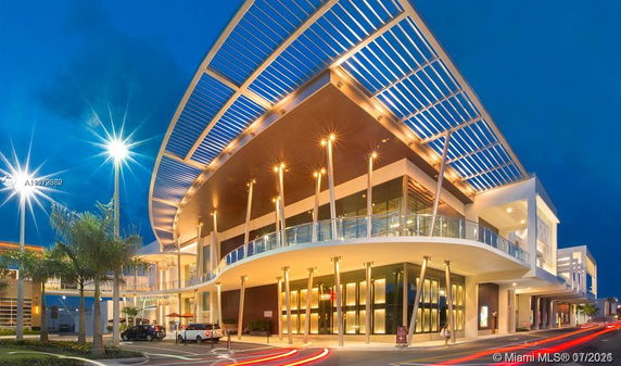 Front view of a modern commercial building with a curved design and large overhanging roof structure.