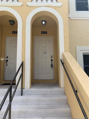 Front view of a building with two entry doors and arched entryways.