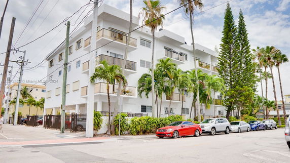 Front view of a multi-story residential building with balconies and white exterior.
