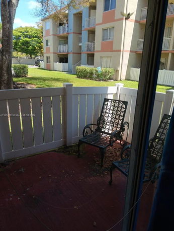 View from a patio area showing apartment buildings and grassy surroundings.