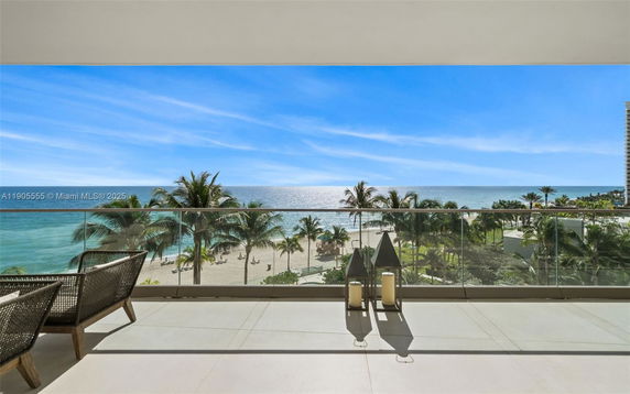 Panoramic view of a beach and ocean from a balcony.