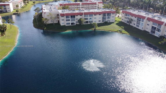 Aerial view of multiple residential buildings near a large water body with a fountain.