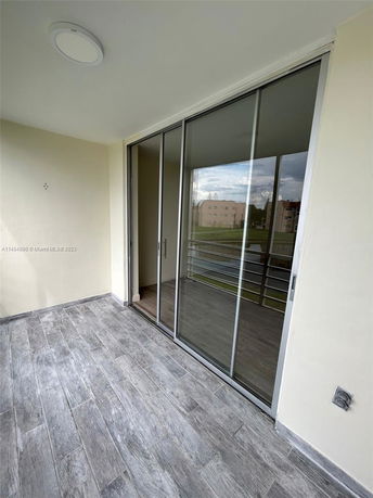 View from a balcony with glass sliding doors and tiled floor.
