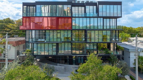 Front view of a modern multi-story building with large glass windows.