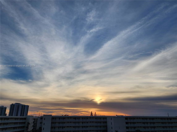 Panoramic view of buildings with a dramatic sky at sunset.