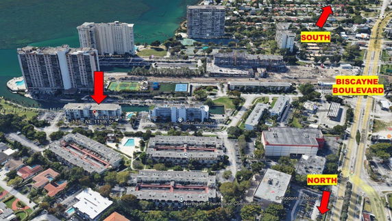 Aerial view of a cityscape featuring high-rise buildings, roads, and pool areas.