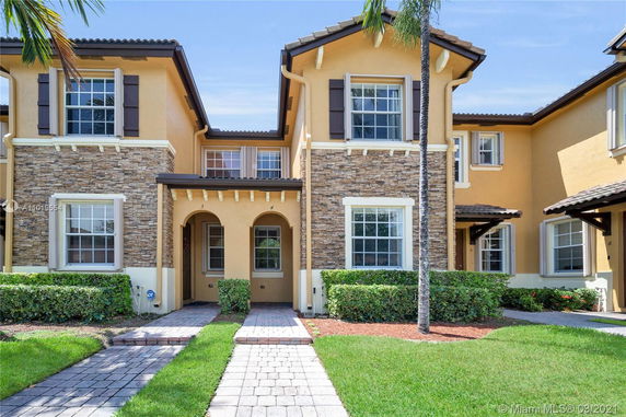 Front view of a two-story house with decorative stone accents and arched entryways.