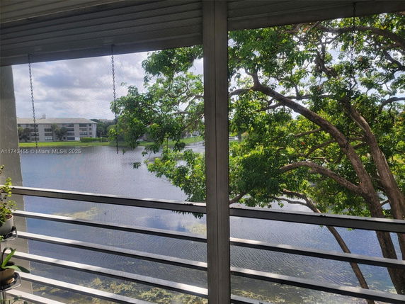 View from a balcony overlooking a lake and nearby buildings.