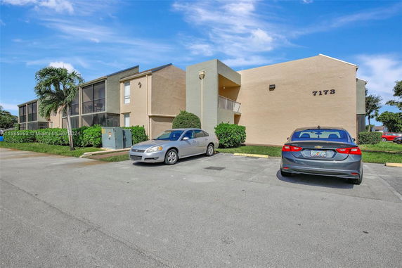 Front view of a multi-story building with a parking area.