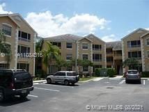 Front view of a multi-story residential building with parking area.