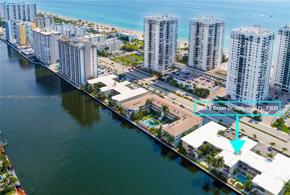 Aerial view of beachfront high-rise buildings along a waterway.