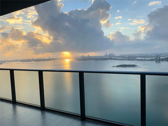Panoramic view of city skyline and water from a building balcony.