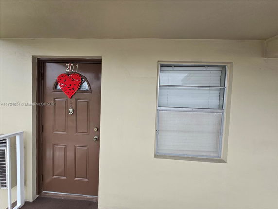 Front view of a door with a heart decoration and adjacent window.