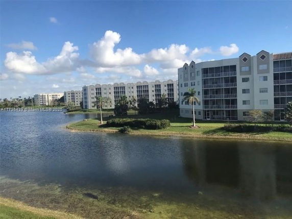 View of a residential complex with multiple multi-story buildings beside a lake.