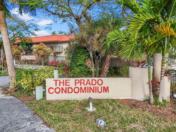 Front view of a condominium complex with a sign reading 'The Prado Condominium.'