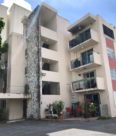 Front view of a multi-story residential building with balconies.